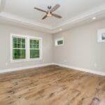 Bedroom remodel with tray ceiling and hardwood flooring